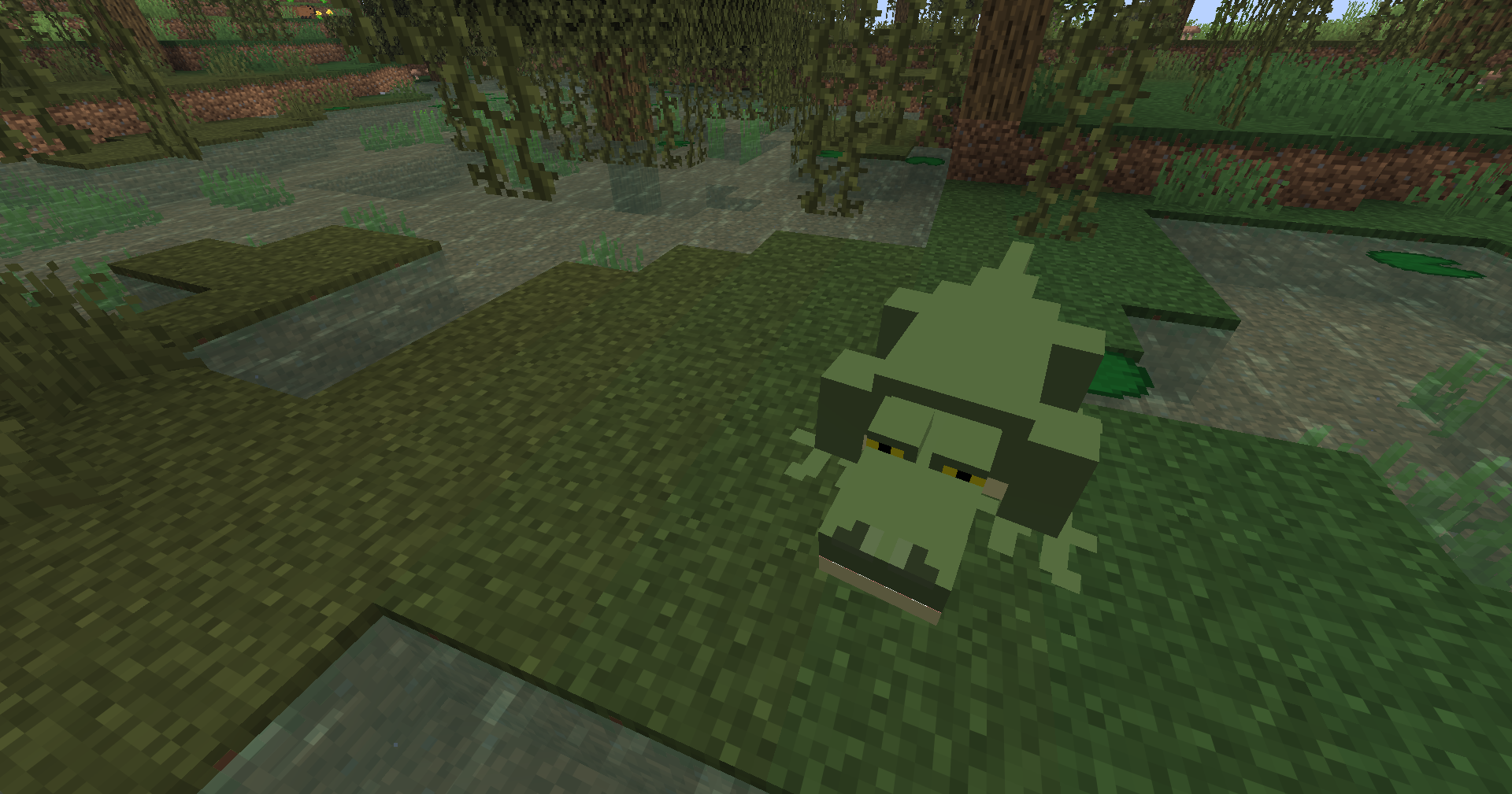 Minecraft swamp screenshot featuring an alligator near shallow water.